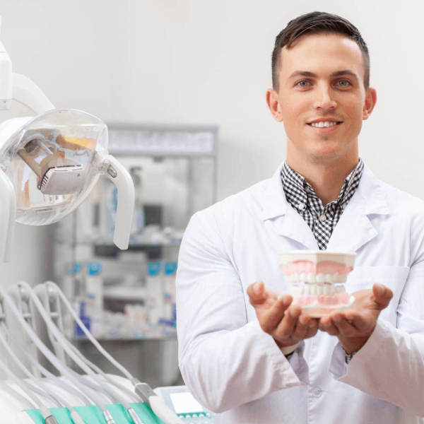 Dentist holding medical material in his clinic